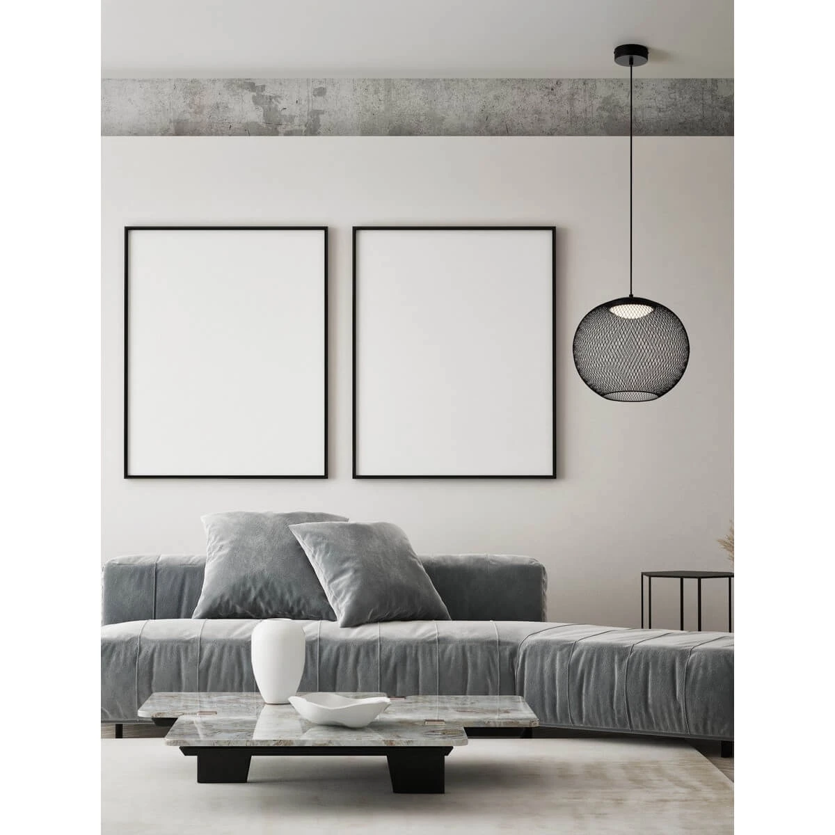 Lampa wisząca Rita w czarnym kolorze z metalowym kloszem w kształcie kuli, zawieszona na cienkim przewodzie. Widoczna w nowoczesnym wnętrzu z szaro-srebrną sofą, białymi dekoracjami na stole oraz pustymi ramkami na ścianie.