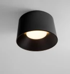 Lampa sufitowa Bajo LED 35W w kolorze czarnym, o cylindrycznym kształcie. Widok z dołu, ukazujący białą oprawę świetlną w środku. Montowana na suficie, minimalistyczny design bez dodatkowych dekoracji.