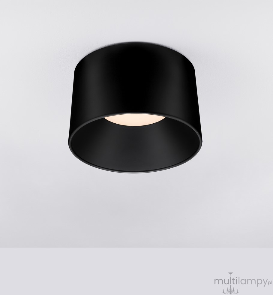Czarna lampa sufitowa LED Bajo o mocy 35W, o cylindrycznym kształcie, zamontowana na suficie. Emituje ciepłe światło, z widocznym okrągłym kloszem i matowym wykończeniem. Prosta forma, idealna do nowoczesnych wnętrz.