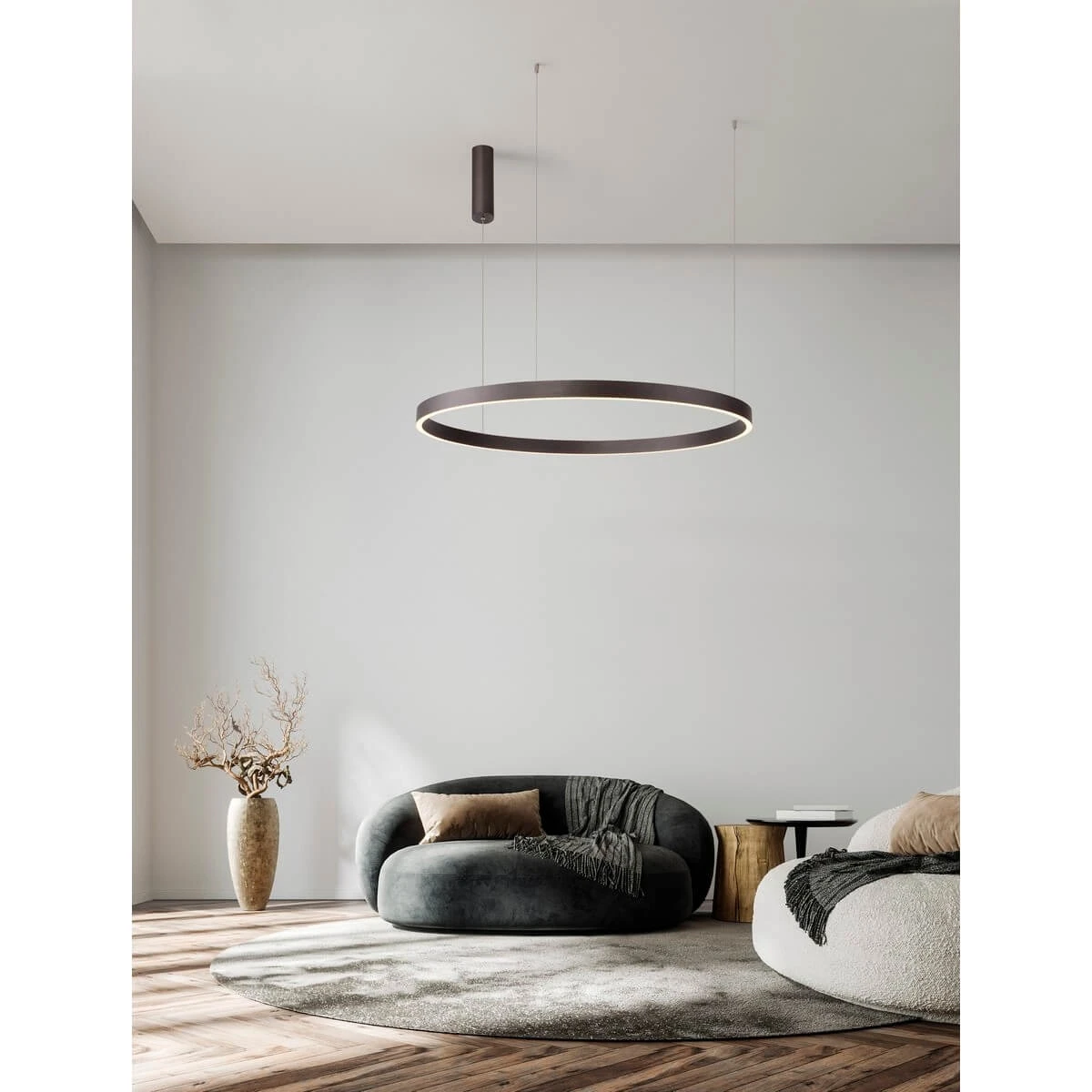 Lampa wisząca Bari D98 w kolorze brązowym, z okrągłym kloszem LED, zawieszona na cienkich linkach. Produkt znajduje się w nowoczesnym wnętrzu z szarymi ścianami, w pobliżu stylowych mebli i dekoracji.