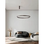 Lampa wisząca Bari D98 w kolorze brązowym, z okrągłym kloszem LED, zawieszona na cienkich linkach. Produkt znajduje się w nowoczesnym wnętrzu z szarymi ścianami, w pobliżu stylowych mebli i dekoracji.