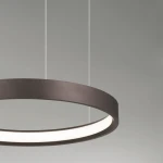Lampa wisząca Zacapu D40 o okrągłym kształcie, wykonana w brązowym kolorze. Zawiera jedną diodę LED 22W, z białym kloszem w centralnej części. Zawieszona na cienkich linkach, prezentuje nowoczesny design. Tło w odcieniach szarości.