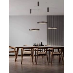Lampa wisząca Zacapu D40 w kolorze brązowym, z pojedynczym źródłem światła LED 22W, zawieszona nad drewnianym stołem. W tle widoczne minimalistyczne wnętrze z drewnianymi krzesłami i dekoracjami.