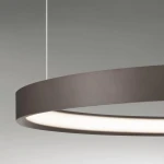 Lampa wisząca Zacapu D60 w brązowym kolorze, z okrągłym, matowym kloszem LED o mocy 40W. Ujęcie zbliżeniowe na górną część lampy, zawieszonej na cienkim przewodzie, z widoczną białą częścią emitującą światło.