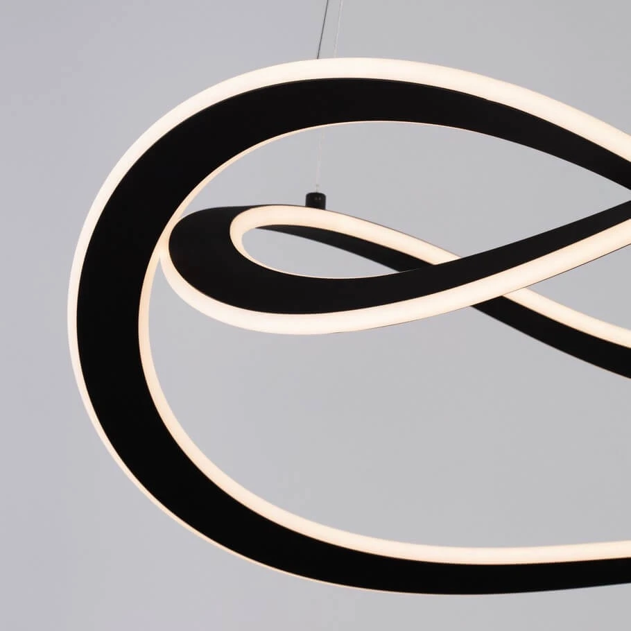 Lampa wisząca Jauja 2xLED 87W w kolorze czarnym, o unikalnym kształcie w formie spiralnych, przeplatających się linii. Elementy świetlne z białym podświetleniem, zawieszona na cienkim przewodzie. Tło w odcieniu szarym.