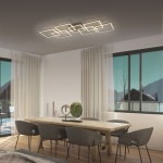 Lampa sufitowa Q-inigo LED 52W CCT w kolorze nikiel satyna, z nowoczesnym, geometrycznym designem. Zainstalowana na suficie w jasnym wnętrzu, z dużymi oknami i drewnianym stołem, tworzy elegancką aranżację.