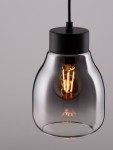 Lampa wisząca Moche z jednym gniazdem E27, w czarnej oprawie. Szklany klosz w kształcie stożka, przezroczysty, z widoczną żarówką w ciepłym odcieniu. Zawieszona na cienkim przewodzie, na jednolitym tle.