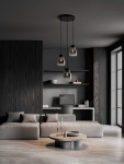 Lampa wisząca Moche z trzema żarówkami E27 w czarnej oprawie. Szklane klosze o opływowym kształcie zawieszone na długich linkach, umieszczone w nowoczesnym wnętrzu z ciemnym drewnem i minimalistycznymi meblami.