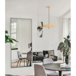 Lampa wisząca Bamepa z jednym gniazdem E27 w kolorze złotym, z dekoracyjnym, okrągłym kloszem w formie siatki. Zawieszona na czarnym kablu, w nowoczesnym wnętrzu z lustrami i roślinami.