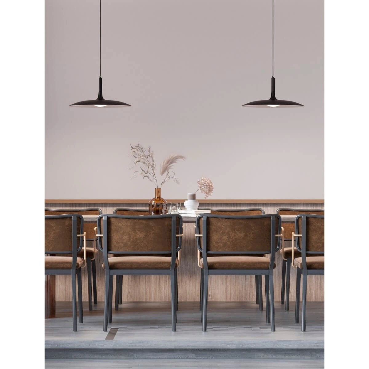 Lampa wisząca Nauta w kolorze czarnym z jedną żarówką LED 16W, zawieszona nad stołem w nowoczesnej aranżacji z drewnianym wykończeniem i metalowymi krzesłami. Tło w jasnych odcieniach, minimalistyczne dodatki.