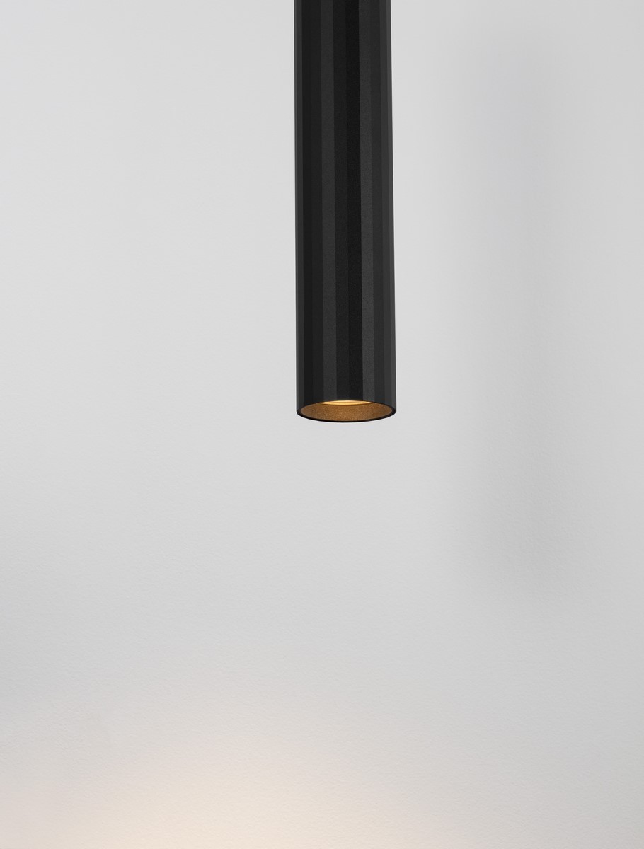 Lampa wisząca Nazca w kolorze czarnym, o cylindrycznym kształcie z widocznym źródłem światła GU10. Ujęcie z góry, pokazujące strukturę zewnętrzną oraz złotą wewnętrzną część klosza. Tło białe, minimalistyczne.