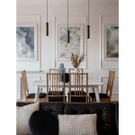 Czarna lampa wisząca Nazca 1xGU10 zawieszona nad białym stołem w jadalni, z drewnianymi krzesłami. W tle widoczne obrazy w ramkach oraz dekoracyjna waza z suszonymi kwiatami. Proste, nowoczesne wnętrze.