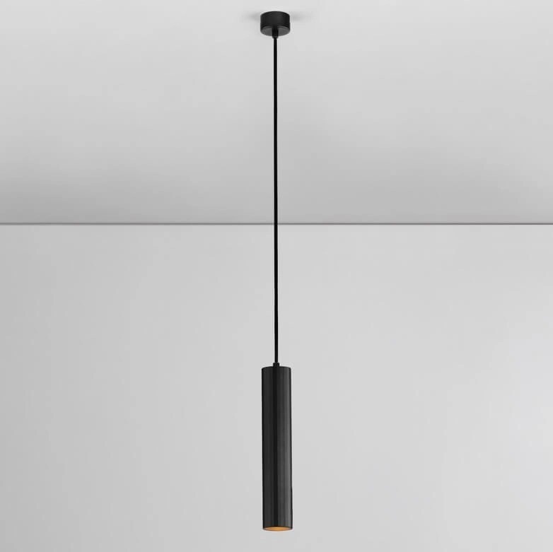 Lampa wisząca Nazca w kolorze czarnym, z pojedynczym źródłem światła GU10. Ma prostokątny, cylindryczny kształt oraz długi, cienki kabel. Zamontowana na suficie, idealna do nowoczesnych wnętrz. Tło jasne, minimalistyczne.