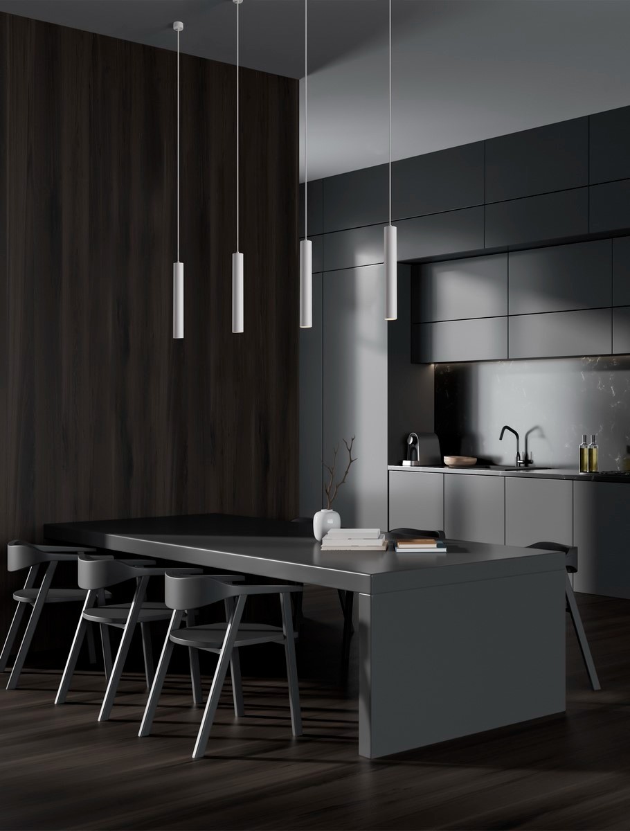 Lampa wisząca Nazca 1xGU10 w kolorze białym, o cylindrycznym kształcie, zawieszona na cienkim przewodzie. Widoczna w nowoczesnej kuchni, z ciemnym drewnianym tłem i eleganckim stołem.