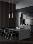 Lampa wisząca Nazca 1xGU10 w kolorze białym, o cylindrycznym kształcie, zawieszona na cienkim przewodzie. Widoczna w nowoczesnej kuchni, z ciemnym drewnianym tłem i eleganckim stołem.