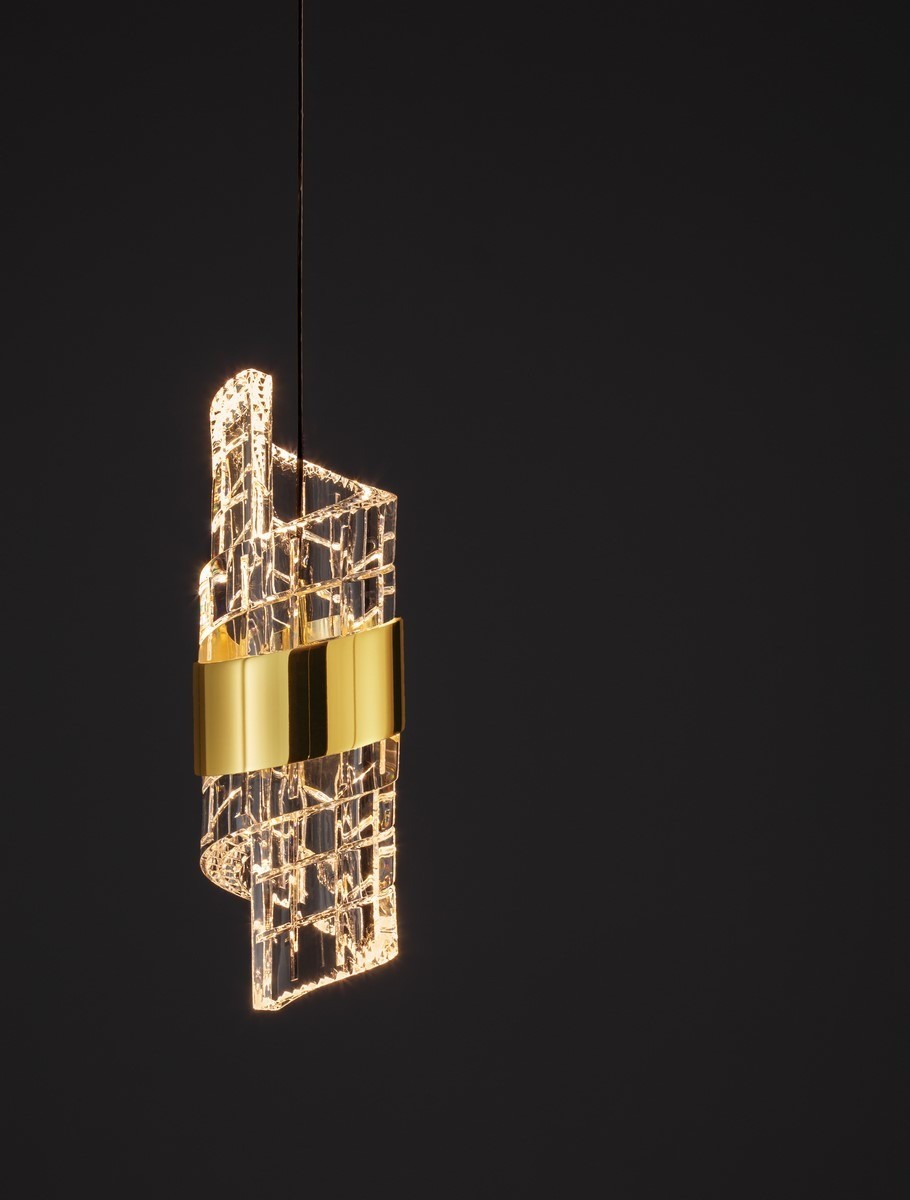 Czarna lampa wisząca Paita z jednym źródłem światła LED 9W, o nowoczesnym, falistym kształcie. Elementy ze szkła z efektem przezroczystości oraz złoty akcent w postaci opaski. Zawieszona na cienkim, czarnym przewodzie, na ciemnym tle.