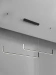 Lampa wisząca Piura w kolorze czarnym z dwoma prostokątnymi ramionami LED, zawieszona na cienkich żyłkach. Ujęcie z dołu, ukazujące minimalistyczny design oraz sufitową podstawę. Idealna do nowoczesnych wnętrz.