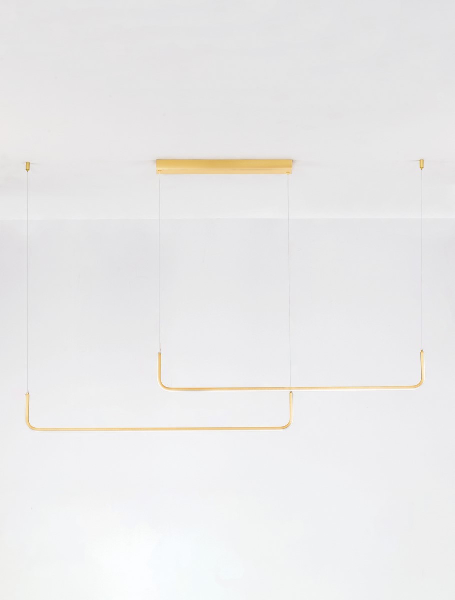 Lampa wisząca Piura 2xLED 40W w kolorze złotym, z minimalistycznym kształtem. Ujęcie z dołu, prezentujące dwa równoległe ramiona zawieszone na cienkich linkach, montowane do sufitu na prostokątnej podstawie.