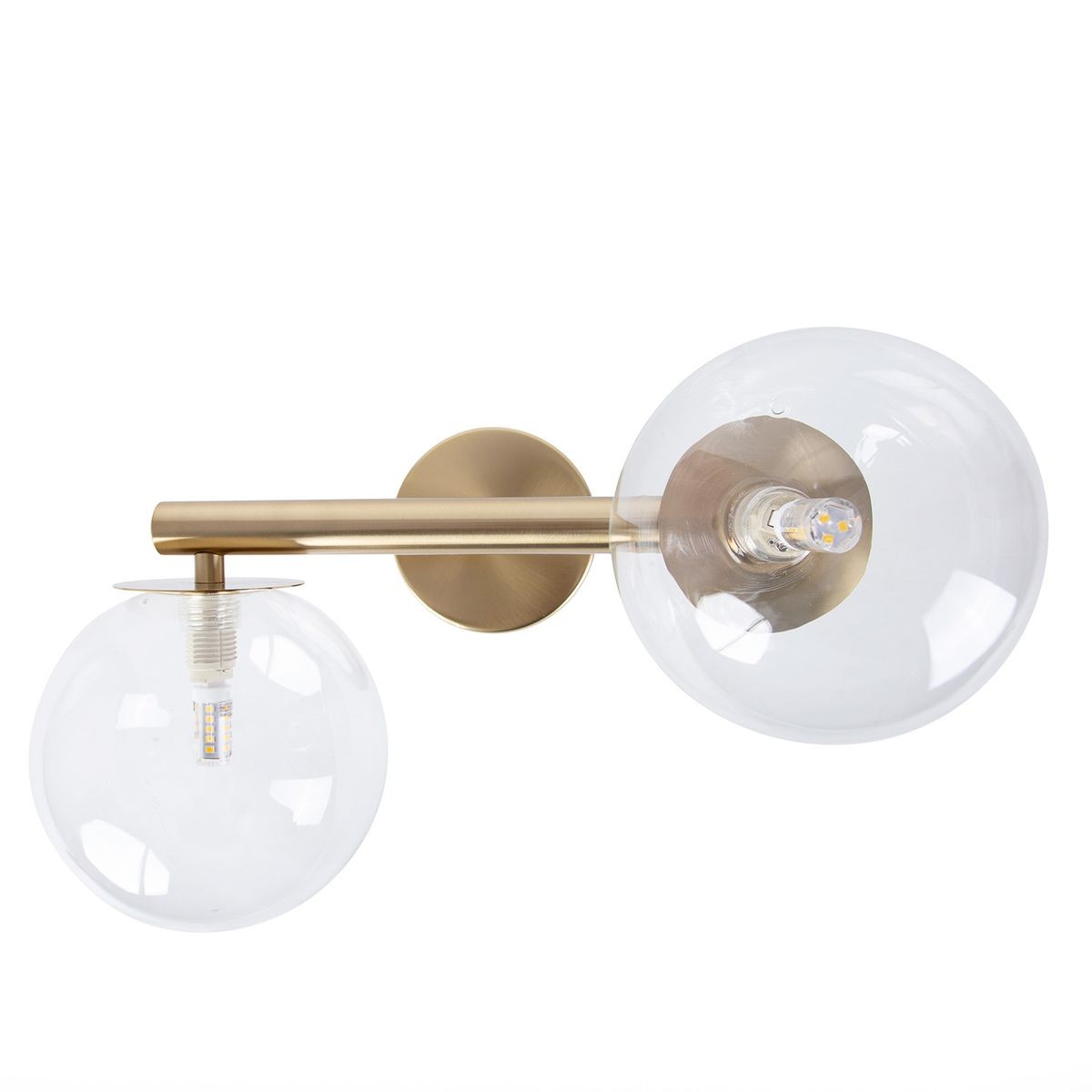 Kinkiet Avola 2xG9 w kolorze złotym z transparentnymi kloszami. Ułożony poziomo, z dwoma okrągłymi kloszami, z widocznymi źródłami światła. Metalowa konstrukcja z matowym wykończeniem. Tło białe.