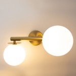 Kinkiet Avola 2xG9 w kolorze złotym i białym, zamontowany na ścianie. Oferuje dwa okrągłe, białe klosze z matowego szkła, umieszczone na prostym, złotym ramieniu. Wzornictwo minimalistyczne, idealne do nowoczesnych wnętrz.