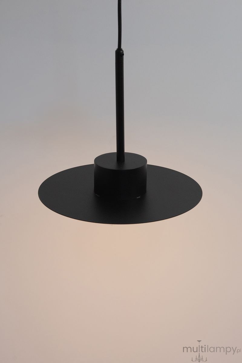 Lampa wisząca Charlie M w kolorze czarnym, z jedną oprawą GX53. Posiada okrągły, płaski klosz oraz prosty, cylindryczny zwis. Ujęcie frontalne, na jednolitym tle, podkreślające minimalistyczny design.