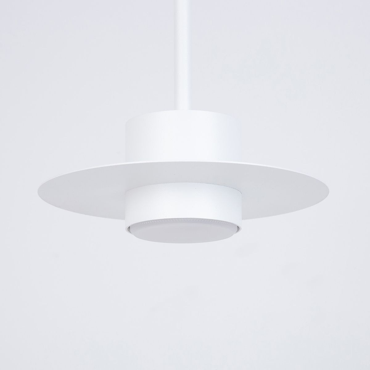 Lampa wisząca Charlie S 1xGX53 w kolorze białym. Okrągły klosz z matowego metalu, z szerokim, płaskim wieńcem. Produkt zawieszony na cienkim, białym przewodzie. Prosty, nowoczesny design, idealny do minimalistycznych wnętrz.