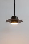 Czarna lampa wisząca Charlie S z jednym źródłem światła GX53. Okrągła podsufitka i szeroki klosz w formie płaskiego talerza, zawieszona na cienkim kablu. Ujęcie z przodu, ukazujące detal i jasne światło.