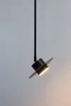 Lampa wisząca Charlie S w kolorze czarnym, z metalowym kloszem i szerokim okrągłym daszkiem. Ujęcie z dołu, prezentujące lampę zawieszoną na cienkim przewodzie, emitującą światło z oprawy GX53. Tło jasne, jednolite.