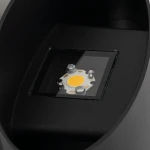 Kinkiet Verto 2xLED 10W IP54 w kolorze czarnym, widoczny w zbliżeniu na źródło światła LED. Elementy montażowe są widoczne, a lampa ma prosty, nowoczesny kształt. Ujęcie z góry, na tle ciemnego materiału.