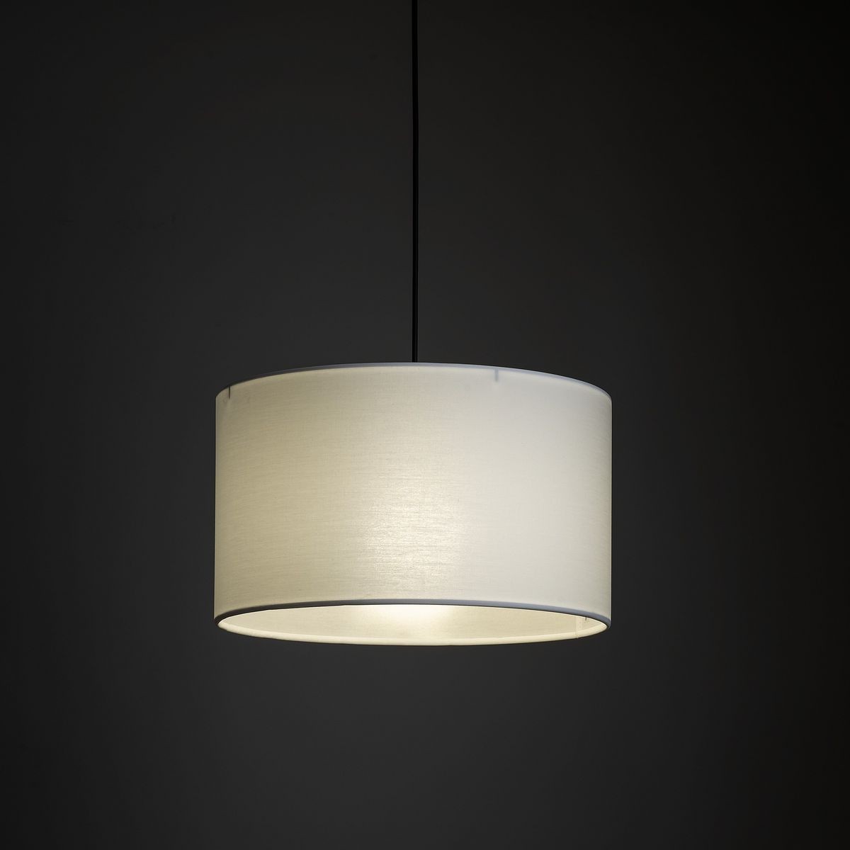 Lampa wisząca Tracer D38 w kolorze czarnym z białym abażurem, o okrągłym kształcie. Zawieszona na cienkim, czarnym przewodzie. Przeznaczona do żarówki E27. Tło ciemne, co podkreśla jasność lampy.