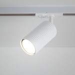 Reflektor spot Tracer Tune 1xGU10 w kolorze białym, zamontowany na szynie. Posiada cylindryczny kształt z wyżłobieniami na powierzchni oraz otwór emitujący światło. Ujęcie z góry, zbliżenie na detal lampy.