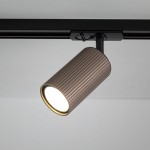 Reflektor spot Tracer Tune 1xGU10 w kolorze brązowym, z teksturowaną obudową, zamontowany na czarnej szynie. Ujęcie z boku, ukazujące źródło światła w kształcie cylindrycznym.