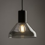Lampa wisząca Tracer Neo w kolorze czarnym z grafitowym wykończeniem, z kloszem w kształcie dzwonu z przezroczystego szkła. Widoczna żarówka E27, zawieszona na cienkim przewodzie. Kąt ujęcia zbliżenie na detal. Tło szare, minimalistyczne.