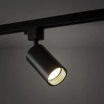 Reflektor spot Tracer Amis 1xGU10 w kolorze czarnym, zamontowany na szynie, z cylindrycznym korpusem. Emituje ciepłe światło, z widoczną żarówką. Ujęcie z boku, pokazujące szczegóły konstrukcji i wykończenia.