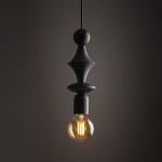Lampa wisząca Tower w kolorze czarnym z pojedynczym gniazdem E27, o nowoczesnym, geometrycznym kształcie. Wisi w pionie z przezroczystą żarówką, na ciemnym tle, podkreślającym jej elegancki design.