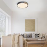 Lampa sufitowa Q-bila LED 35W CCT w kolorze czarnym z drewnianymi akcentami, zamontowana na suficie. Okrągła, z miękkim, rozproszonym światłem, idealna do nowoczesnych wnętrz. W tle widoczny komfortowy salon z kanapą i dekoracyjnymi poduszkami.