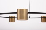 Lampa wisząca Kodo w kolorze czarnym i mosiądzu, z pięcioma uchwytami na żarówki GX53. Widok z bliska na metalowe detale oraz okrągłą, prostą konstrukcję. Tło białe, podkreślające elegancki design.