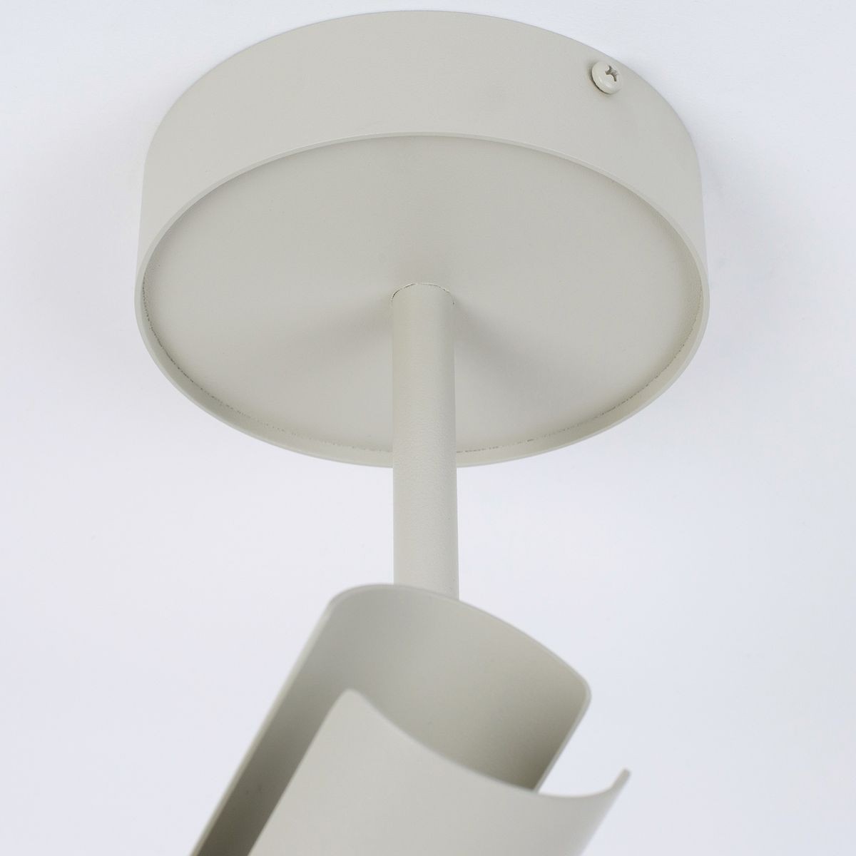 Leda lampa sufitowa w kolorze szaro-beżowym, z pojedynczym ramieniem na żarówkę GU10. Ujęcie z dołu, pokazujące okrągły sufitowy uchwyt oraz gięty element lampy. Prosta, nowoczesna konstrukcja, idealna do oświetlenia wnętrz.