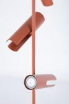 Lampa wisząca Leda w kolorze ceglastym z trzema oprawami na żarówki GU10. Ujęcie z boku, ukazujące metalowy, cylindryczny kształt kloszy oraz ich montaż na cienkim pręcie. Prosta struktura, matowa powierzchnia, minimalizm i nowoczesny design.