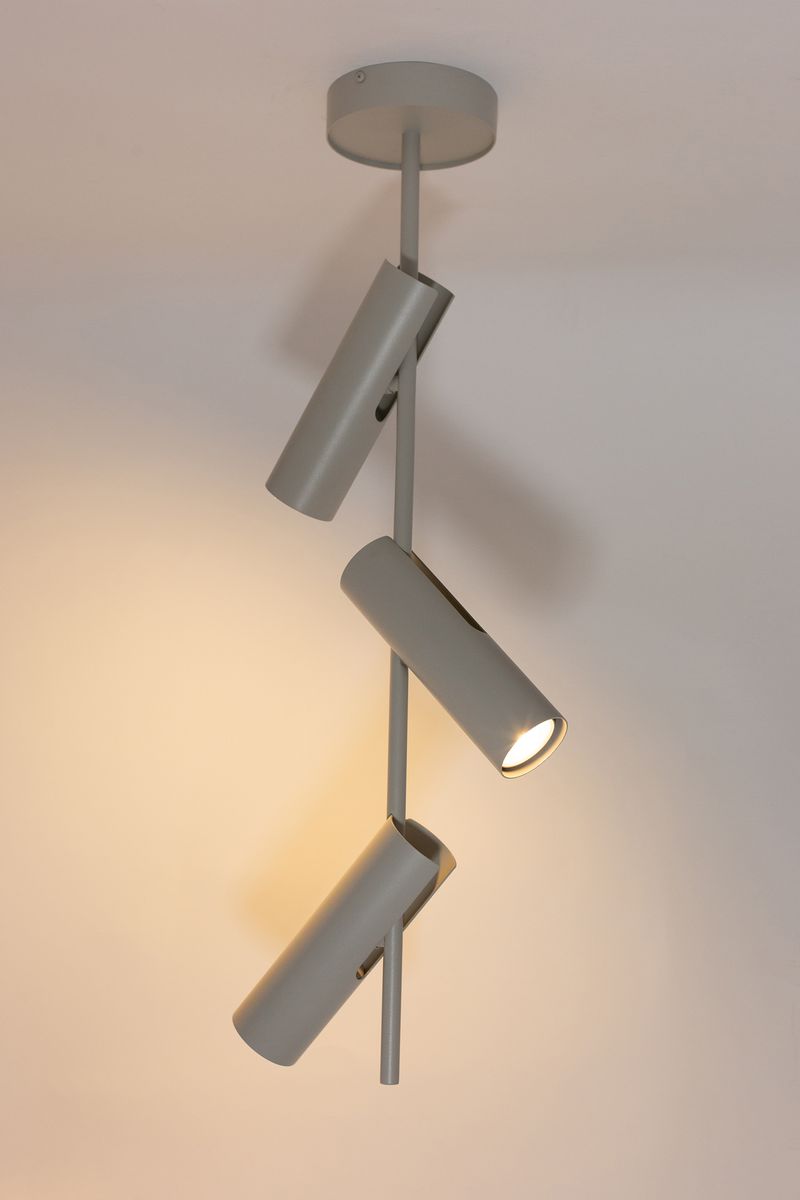 Leda lampa wisząca z trzema reflektorami GU10, w kolorze szarym beżowym. Ułożona pionowo, z reflektorami skierowanymi w różne strony. Metalowa konstrukcja z okrągłym mocowaniem sufitowym. Tło jasne, minimalistyczne.