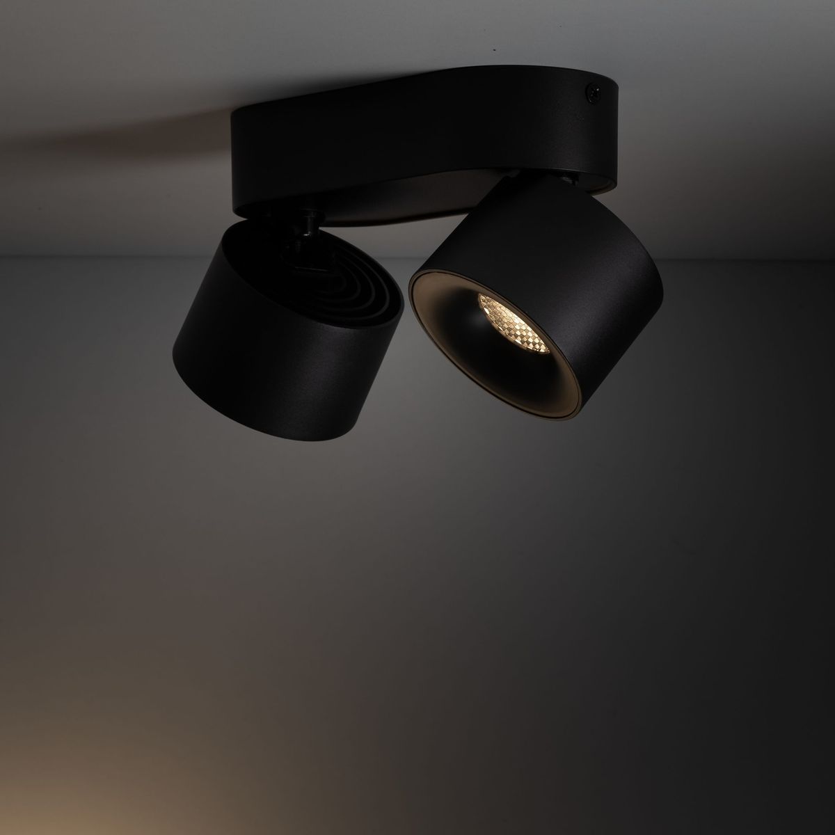 Lampa sufitowa Spark z dwoma reflektorami LED 20W w kolorze czarnym. Reflektory mają cylindryczny kształt, umieszczone na płaskiej bazie. Ujęcie z dołu, pokazujące detale konstrukcji i źródła światła.