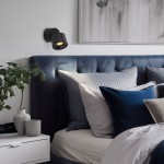Lampa sufitowa Spark, czarna, z jedną żarówką LED 10W CCT, zamontowana na ścianie nad łóżkiem. Oświetlenie skierowane na poduszki w odcieniach szaro-niebieskich, z widocznym obrazem w tle. W otoczeniu rośliny doniczkowe i minimalistyczna szafka nocna.