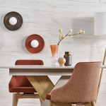 Czarny kinkiet Slate 1xG9 z okrągłym, białym kloszem, zamontowany na ścianie. W tle widoczne dekoracyjne talerze oraz nowoczesne meble w odcieniach brązu i beżu, tworzące elegancką aranżację wnętrza.