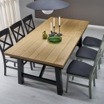 Lampa wisząca Slate 1xE27 w kolorze czarnym, zawieszona nad drewnianym stołem, z okrągłym kloszem. W tle widoczne cztery krzesła i dekoracje na stole, takie jak świeczniki i szklana misa. Tło w stonowanych kolorach.