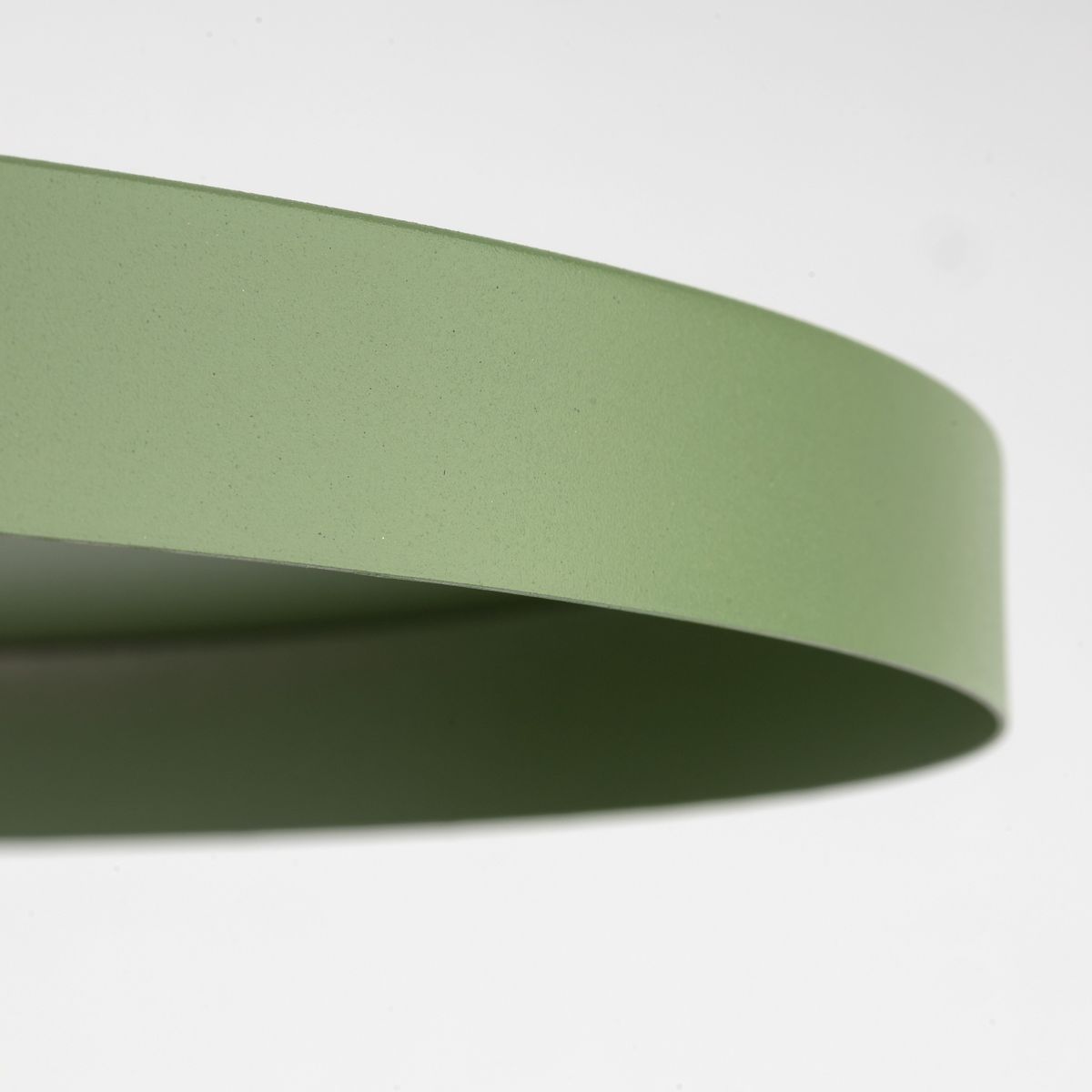 Lampa wisząca Sila D40 w kolorze zielonym z oprawą w kształcie cienkiego pierścienia. Materiał matowy z delikatną teksturą. Widoczny krawędź lampy, montaż na jedną żarówkę E27. Tło jasne, co podkreśla kolor lampy.