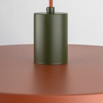 Lampa wisząca Sila D40 z mocowaniem w kolorze zielonym, osadzona na okrągłej podstawie w odcieniu ceglastym. Widoczny kabel w kolorze pomarańczowym, kształt cylindryczny, matowa tekstura. Ujęcie z bliska, pokazujące detal mocowania.