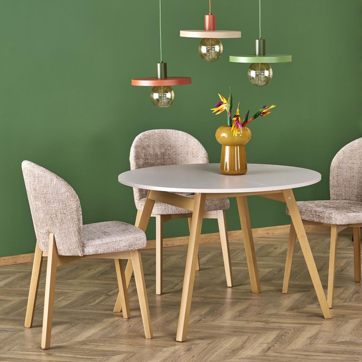 Lampa wisząca Sila D30 w kolorze brązowym ceglastym z oprawką na żarówkę E27, zawieszona nad okrągłym stołem. W tle zielona ściana, obok trzy krzesła z jasnym obiciem. W aranżacji widoczny wazon z kwiatami.