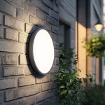 Kinkiet Sferis 1xLED 18W IP54 w kolorze czarnym, umieszczony na ceglanej ścianie. Okrągły klosz z białym szkłem emituje światło, otoczony zielonymi roślinami, co tworzy przyjemny klimat. Zamontowany na zewnątrz, idealny do oświetlenia przestrzeni.