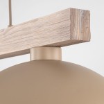 Lampa wisząca Oslo z jasnego drewna i beżowym kloszem, zawieszona na metalowej oprawie. Widoczny detal drewnianego uchwytu oraz okrągłego klosza. Produkt w neutralnym, jasnym otoczeniu, zbliżenie na połączenie materiałów.