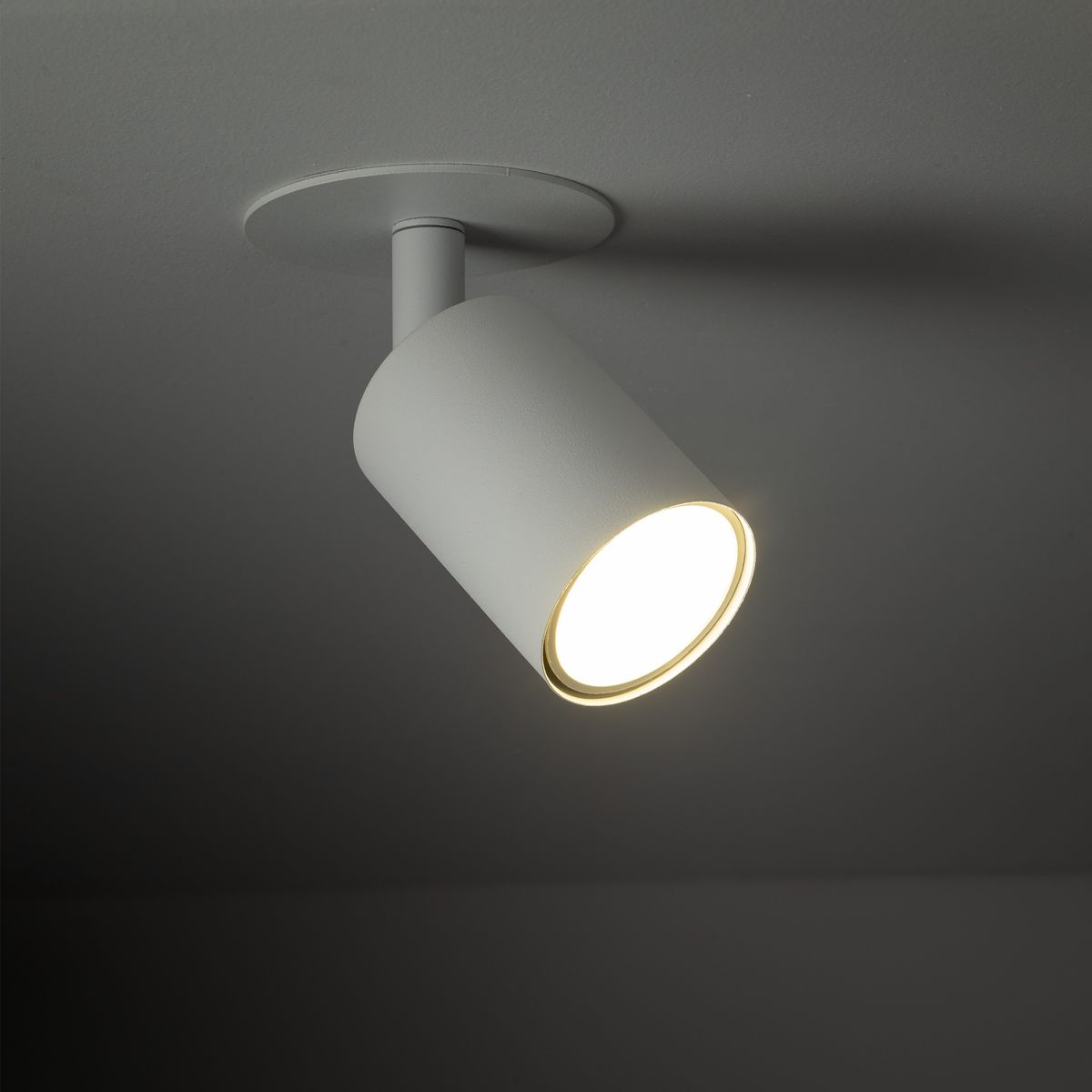 Lampa sufitowa podtynkowa Nex 1xGU10 w kolorze białym, z cylindrycznym korpusem. Ujęcie z boku, pokazujące źródło światła oraz detale mocowania do sufitu. Prosta, minimalistyczna forma, idealna do nowoczesnych wnętrz.